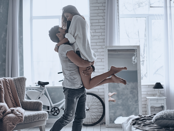 Mann hebt junge Frau romantisch hoch