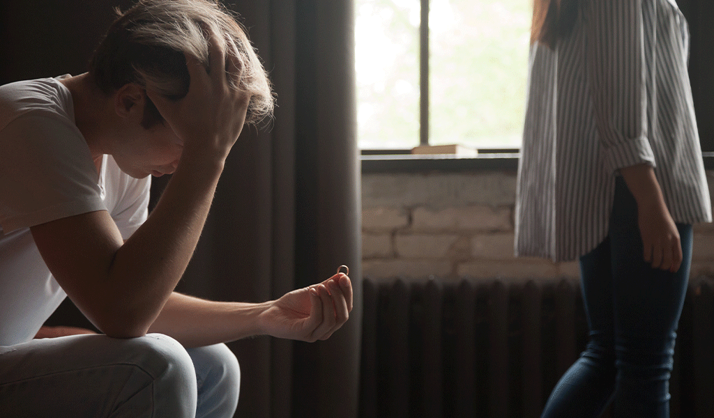Junger Mann mit Alkoholflasche wird von Freundin unterstützt