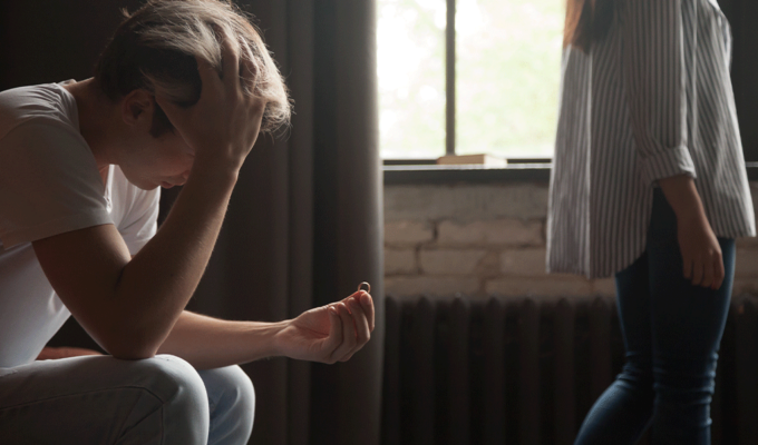 Junger Mann mit Alkoholflasche wird von Freundin unterstützt