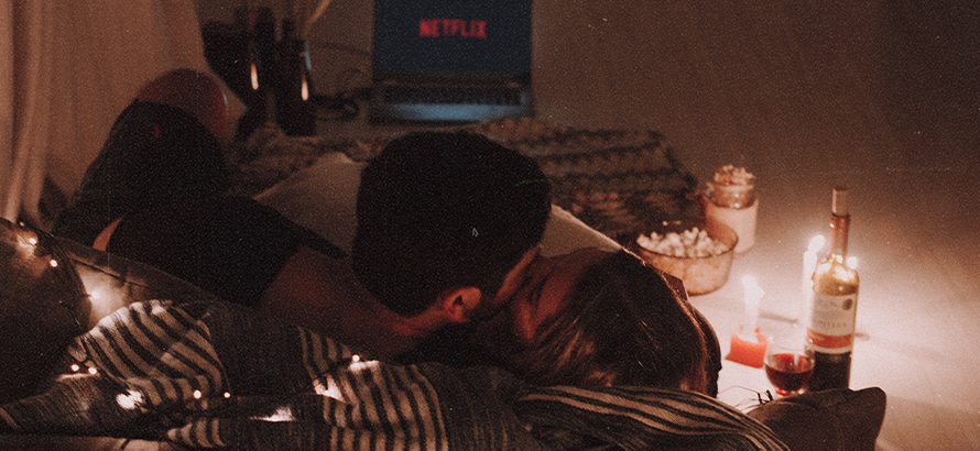 Paar küsst sich während es Netflix schaut