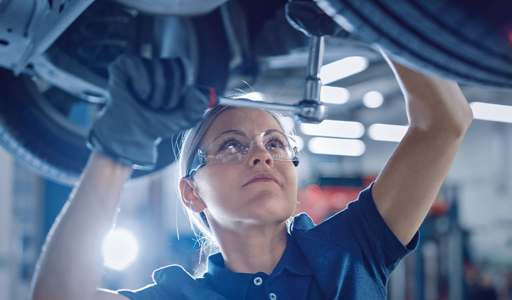 Frau schraubt am Auto