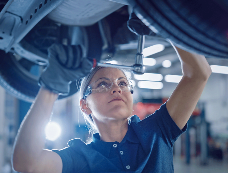 Frau schraubt am Auto