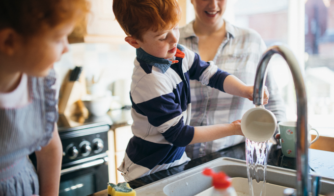 Familie spült zusammen das Geschirr