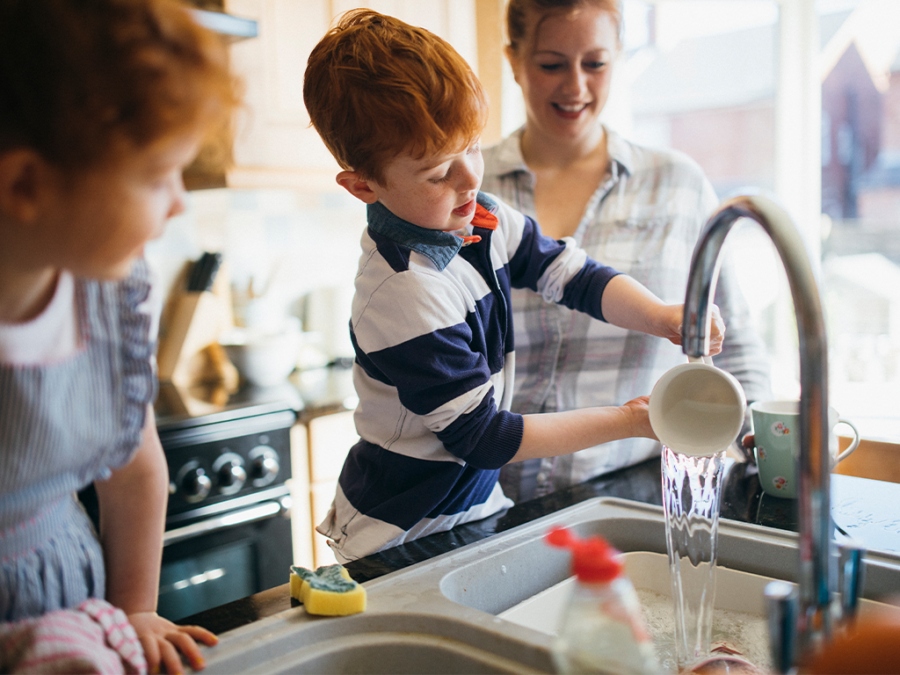 Familie spült zusammen das Geschirr