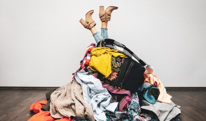 Frau in Klamottenhaufen