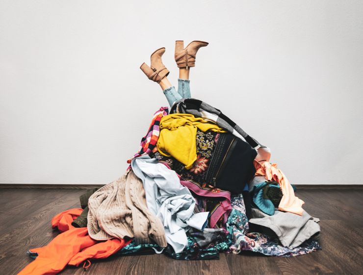 Frau in Klamottenhaufen