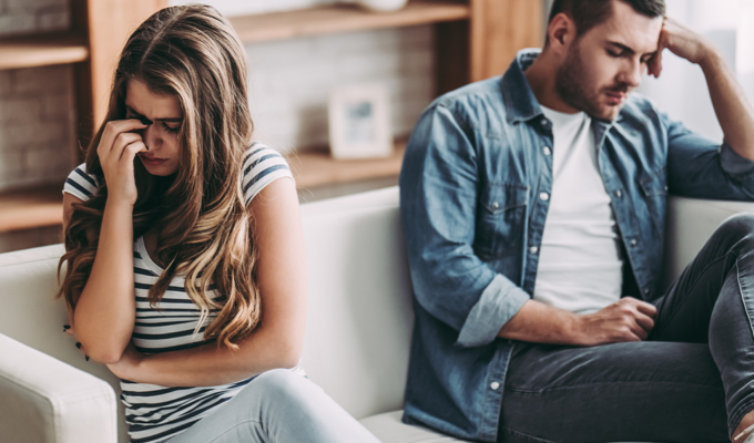 Junges Paar trennt sich und sitzt in Trauer zusammen auf der Couch