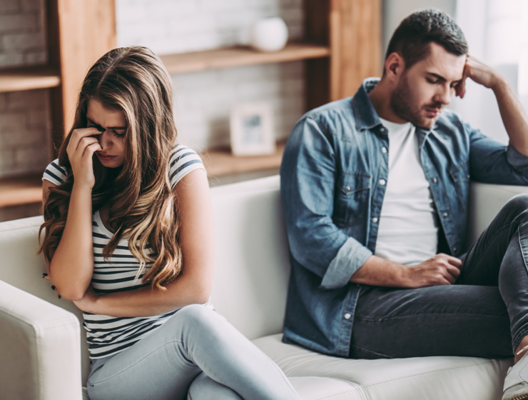 Junges Paar trennt sich und sitzt in Trauer zusammen auf der Couch